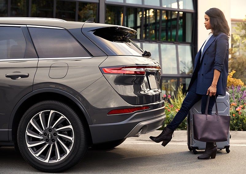 A woman with her hands full uses her foot to activate the available hands-free liftgate. | Mike Reichenbach Lincoln in Florence SC